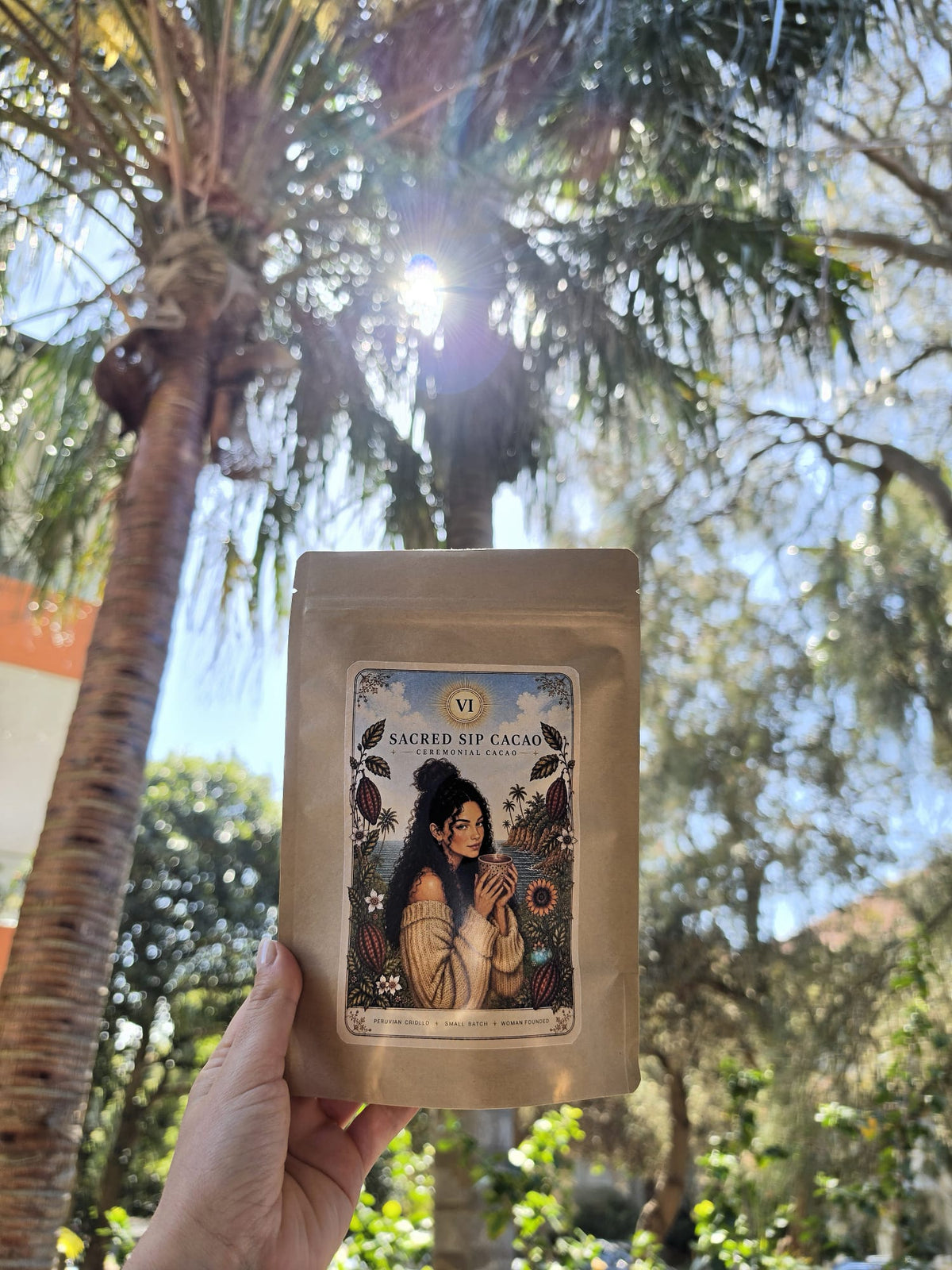 Sacred Sip Cacao pouch with a palm tree and sun in the background
